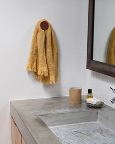 a bathroom sink with a yellow towel hanging on the wall