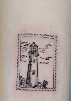 a postage stamp with a lighthouse on it's left arm and an image of the ocean