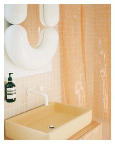 a bathroom with a sink, mirror and soap dispenser on the wall