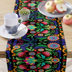 a table topped with plates and cups filled with fruit next to an empty plate on top of a wooden table