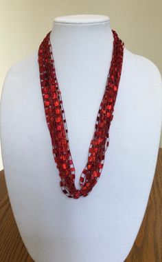 A beautiful and unique handmade accessory that shimmers and portrays a beaded look! Each necklace is handmade and is easy to wear - just slip it over your head. Necklace is very lite weight and is available in many stunning great colors. Comes packaged in an organza bag. A great gift item. Necklace is 28 inches in length and is made of 97% Nylon and 3% Lurex. Handwash in cold water and lay flat to dry. Each item is made by hand and slight variations may occur. Long Red Beaded Necklaces For Parties, Red Long Beaded Necklaces For Party, Red Long Beaded Necklace For Party, Handmade Thread Jewelry For Party, Handmade Red Beaded Necklace For Holidays, Red Handwoven Necklace For Gift, Red Handwoven Beads For Jewelry Making, Gift Red Handwoven Beaded Necklaces, Red Handwoven Necklaces With Round Beads