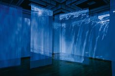 an empty room with blue curtains on the walls and water running down the wall behind it