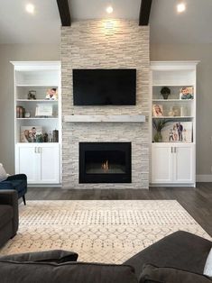 a living room with couches and a fireplace in the center, surrounded by built - in shelving