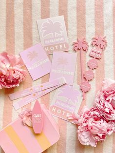 pink and yellow items are laid out on a striped blanket with flowers in the background