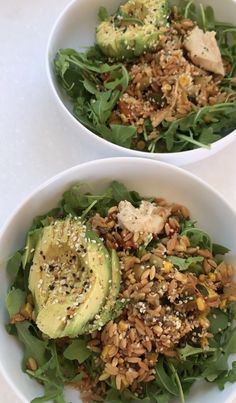 two white bowls filled with salad and topped with avocado