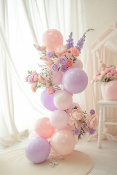 a bunch of balloons that are sitting on a table in front of a window with flowers