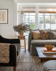 a living room with two couches and a coffee table in front of a window