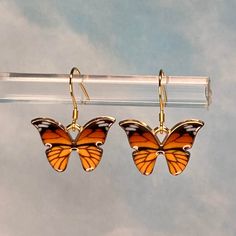 "These orange and black monarch butterfly charms dangle from 14K gold-plated 925 silver wires, so they are hypoallergenic and nickel-free.  The butterfly measures 15 x 21 mm, and the entire earring measures about 1 1/4\" long.  The charms are gold-plated zinc alloy, lead and nickel free. The pair comes with the rubber earring guard backs, packaged in a kraft cotton-filled box. I have only listed the amount of earrings I have currently in stock.  If you would like more earrings in this style, I can make them to order. I will combine shipping if multiple items are ordered." Orange Butterfly-shaped Jewelry Gift, Orange Butterfly Jewelry For Gifts, Orange Butterfly Jewelry Gift, Mother Christmas Gifts, Butterfly Charm, Monarch Butterfly, Butterfly Earrings, Online Earrings, The Butterfly