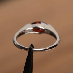 It is a natural garnet ring. The main stone is 5 mm* 10 mm marquise cut.weight about 1.35 carats. The basic metal is sterling silver and plated with rhodium. To change the metal to a solid gold (white/rose) or platinum is also available, please ask for a quotation if you want. You can also go to my shop Home for more elegant rings: https://www.etsy.com/shop/godjewelry?ref=hdr_shop_menu Garnet is January birthstone More garnet rings: https://www.etsy.com/shop/godjewelry?ref=seller-platform-mcnav& Marquise Cut Garnet Jewelry Gift, Modern Garnet Rings For Anniversary, Garnet Marquise Cut Jewelry Gift, Modern Garnet Jewelry For Anniversary, Silver Marquise Cut Ruby Promise Ring, Marquise Garnet Ring As Gift, Marquise Garnet Ring For Anniversary, Silver Marquise Ruby Ring, Gift Marquise Cut Ring With Polished Finish