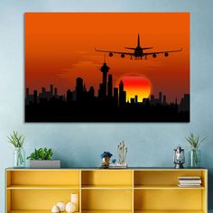 an airplane flying over a city at sunset with the sun setting in the sky behind it