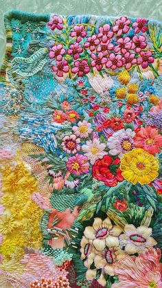 a colorful quilt with flowers and leaves on it