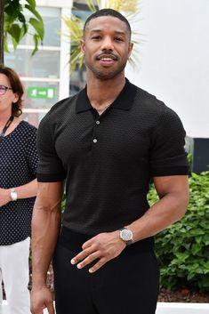 a man in black shirt and white pants