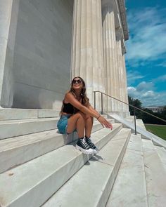 a woman sitting on steps in front of the lincoln memorial