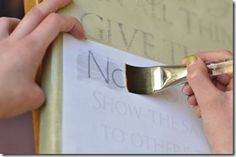 two hands holding a paintbrush over a piece of paper