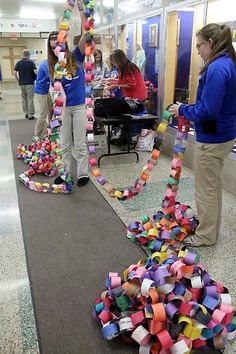 several people are standing in the hallway with colorful streamers