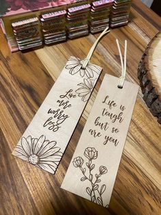 two wooden bookmarks that say life is tough but so are you on a table