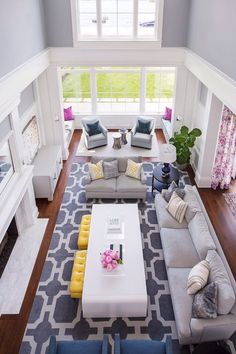 an aerial view of a living room with gray couches and yellow accents