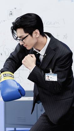 a man in a suit and blue boxing gloves