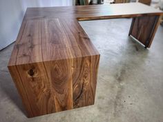 a wooden desk sitting on top of a cement floor