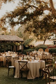 an outdoor dining area with tables and chairs set up for formal dinner in the shade