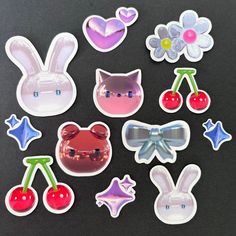 several stickers with different designs and colors on black background, including cherries, cherry, cat ears, bunny ears, flowers, and more