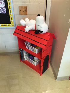 a red shelf with a stuffed animal on top