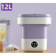 a purple and white ice cream maker sitting on top of a table next to a vase