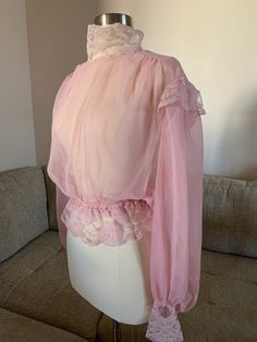 We have here a beautiful silk sheer pink 1910s Victorian/Edwardian blouse trimmed with Chantilly lace trim at the high neck lace collar, trimmed with lace at the cap and the bottom of the long gathered poet sleeves and has an elastic (newer) waist with lace trim. Snaps on both sleeves and at the back neckline and the lower back. There are loops on each side of the gathered waist to thread a pink or white ribbon as a belt. This would have been worn over a camisole. This is a museum quality vintag Pink Lace Trim Blouse, Vintage Pink Long Sleeve Blouse, Vintage Long Sleeve Pink Blouse, Victorian Lace Blouse With Lace Trim, Edwardian Lace Blouse, Edwardian Blouse, Pink Lady, Pink Collars, Antique Clothing