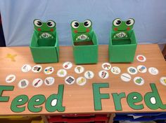 three frogs are sitting on top of a table with buttons and magnets in front of them