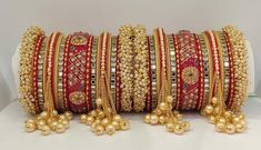 Traditional Punjabi Style Hanging Pearls Chura Set. Decorated With Beautiful Pearls Bunches Bangles At Both End Of Chura. Center Piece Is Prettified With Exclusive Rajwadi Style Hand Painting and Glass Kundan Beading On it. Hanging Pearls Chain At Both Side Of This Chura Is Making This Ensemble More Traditional Yet Elegant. A Glorious Masterpiece To Make You Look Glowy On Any Celebration. This is a set of 34 Bangles (17 For Each Hand). Festive Bridal Accessories With Tilla For Marriage, Bollywood Bridal Accessories For Marriage, Ceremonial Bridal Sets With Latkans For Festivals, Traditional Bridal Accessories For Festivals, Traditional Bridal Accessories For Festive Season, Festive Ceremonial Bridal Sets With Latkans, Bridal Sets With Pallu For Marriage Festivals, Traditional Bridal Sets For Marriage, Heavy Bridal Sets For Marriage And Festive Occasions