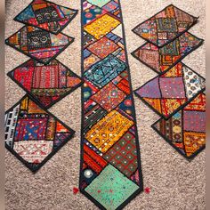 a very long piece of art made out of patchwork material on top of carpet