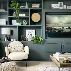 a living room filled with lots of furniture next to a wall covered in bookshelves