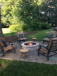 an outdoor fire pit with chairs around it