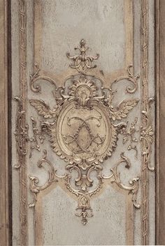 an ornate design on the side of a door with gold trimmings and scrolls