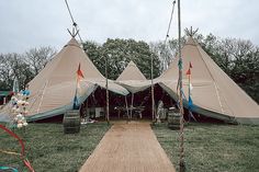 a group of teepees sitting on top of a lush green field