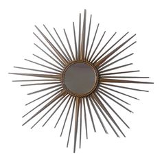 a gold sunburst mirror on a white wall