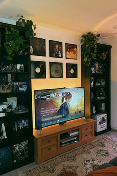 a flat screen tv sitting on top of a wooden entertainment center in a living room