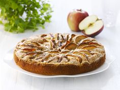 a cake on a plate with apples and parsley in the backgroung