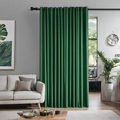 a living room with green curtains and a white couch in front of a large window