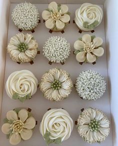 twelve cupcakes in a box decorated with flowers