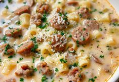 a white bowl filled with pasta and sausage