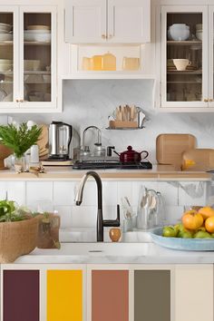 a kitchen with white cabinets and lots of different color swatches on the counter tops