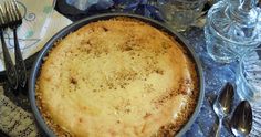 a pie sitting on top of a table next to utensils and silverware