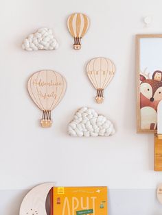 wooden hot air balloons are mounted on the wall above a bookcase and other toys