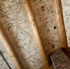 an unfinished room with decorative wallpaper and wooden beams