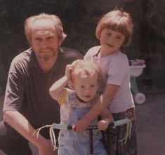 an older man and two young children on a bike