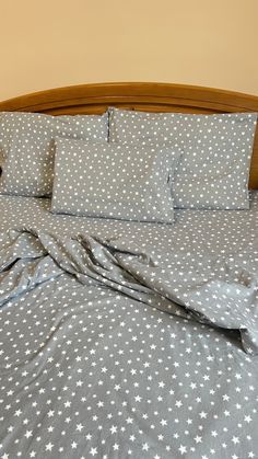 an unmade bed with blue and white stars on it