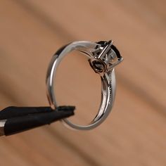 It is a natural black spinel ring. The main stone is 7mm*7mm round cut, weight about 1.65 carats. The basic metal is sterling silver and plated with rhodium. To change the metal to a solid gold (white/rose) or platinum is also available, please ask for a quotation if you want. You can also go to my shop Home for more elegant rings: https://www.etsy.com/shop/godjewelry?ref=hdr_shop_menu More black spinel rings: https://www.etsy.com/shop/godjewelry?ref=seller-platform-mcnav&section_id=21680005 Modern 14k White Gold Round Jewelry, 14k White Gold Open Ring With Brilliant Cut, Diamond Solitaire Open Ring Jewelry, Minimalist Cubic Zirconia Rings With Tension Setting, Minimalist Cubic Zirconia Round Band Jewelry, Minimalist Jewelry With Prong Setting For Promise, Minimalist Cubic Zirconia Jewelry, Formal Stainless Steel Round Band Jewelry, Sterling Silver Jewelry With Brilliant Cut For Promise Ring