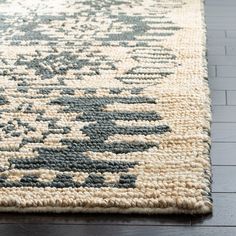 a large rug with an abstract design on the bottom and grey, beige, and white colors