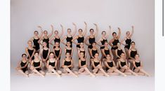 a group of women in black leotards posing for a photo with their arms up